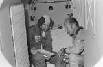 Soviet and American ASTP commanders in Soyuz orbital module mock-up