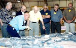 KENNEDY SPACE CENTER, FLA. - In the Columbia Debris Hangar, members of the Stafford-Covey Return to Flight Task Group (SCTG) look at tiles recovered. Chairing the task group are Richard O. Covey, former Space Shuttle commander, and Thomas P. Stafford (center), Apollo commander. Chartered by NASA Administrator Sean O’Keefe, the task group will perform an independent assessment of NASA’s implementation of the final recommendations by the Columbia Accident Investigation Board.