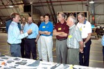 KENNEDY SPACE CENTER, FLA. - In the Columbia Debris Hangar, Shuttle Launch Director Mike Leinbach (left) talks to members of the Stafford-Covey Return to Flight Task Group (SCTG) about reconstruction efforts. Chairing the task group are Richard O. Covey (second from right), former Space Shuttle commander, and Thomas P. Stafford, Apollo commander. Chartered by NASA Administrator Sean O’Keefe, the task group will perform an independent assessment of NASA’s implementation of the final recommendations by the Columbia Accident Investigation Board.