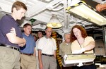 KENNEDY SPACE CENTER, FLA. - Martin Wilson, with United Space Alliance, describes an orbiter’s Thermal Protection System for members of the Stafford-Covey Return to Flight Task Group (SCTG). Handling some of the blanket insulation are Dr. Kathryn Clark and Joe Engle. Third from left is Richard Covey, former Space Shuttle commander, who is co-chair of the SCTG, along with Thomas P. Stafford, Apollo commander. Chartered by NASA Administrator Sean O’Keefe, the task group will perform an independent assessment of NASA’s implementation of the final recommendations by the Columbia Accident Investigation Board.